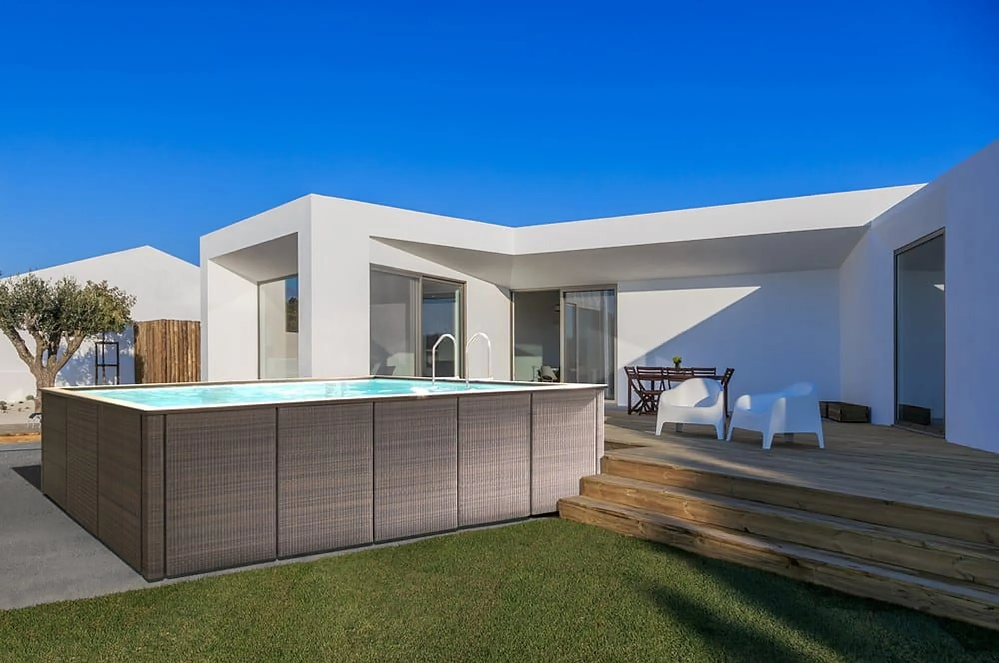 Piscina fuori terra Laghetto installata in giardino accanto a una villa bianca