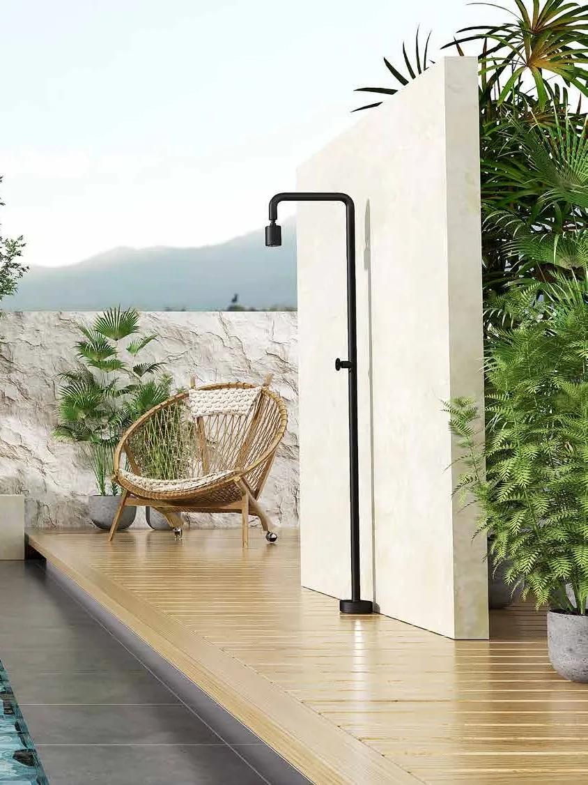 Doccia da esterno nera su pedana in legno, accanto alla piscina e al verde